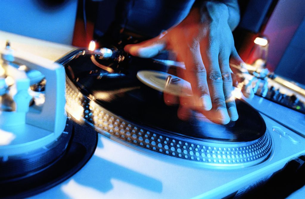 DISC JOCKEY, HAND ON TURNTABLE, CLOSE-UP (LONG EXPOSURE)