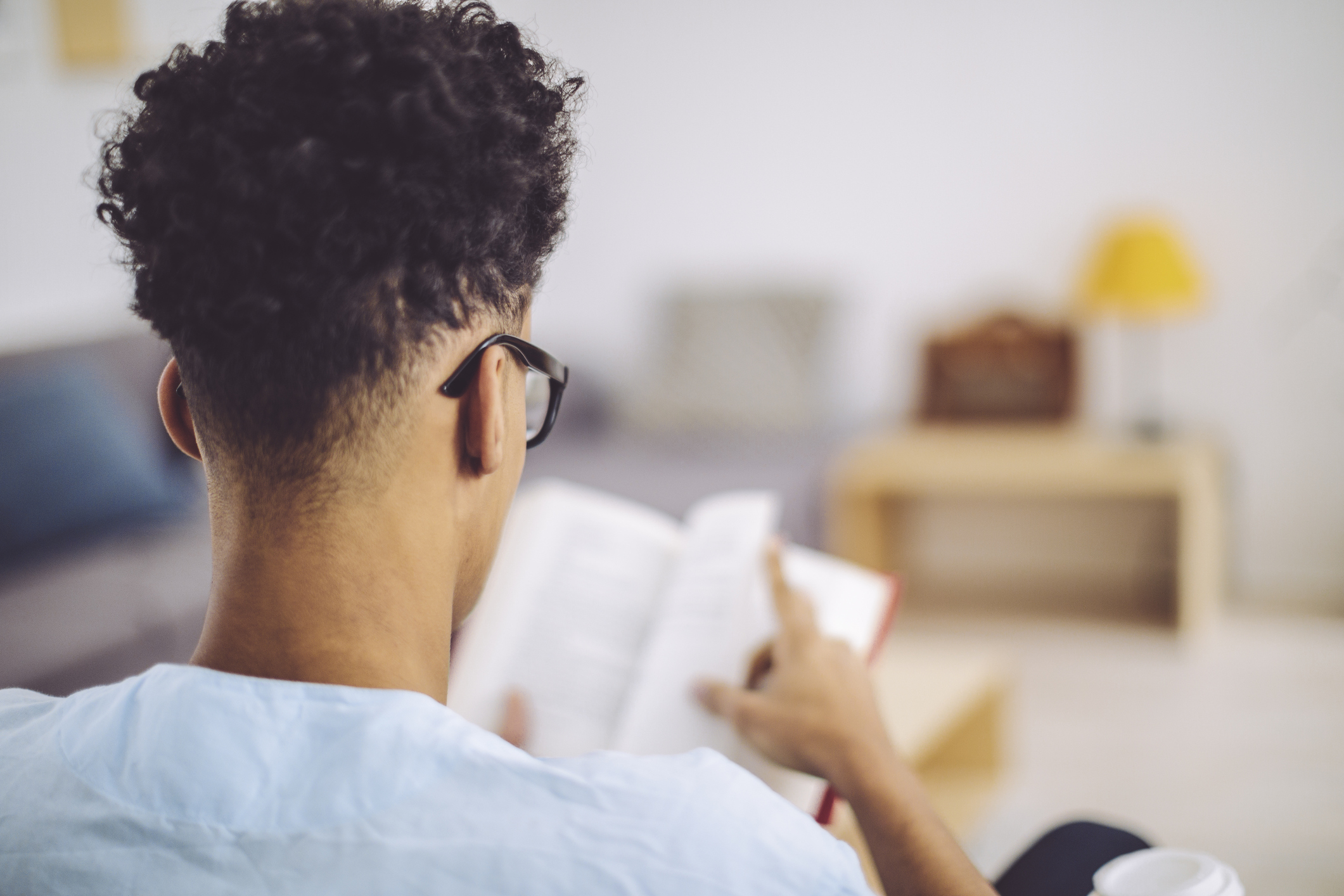 Young man reading a book at home